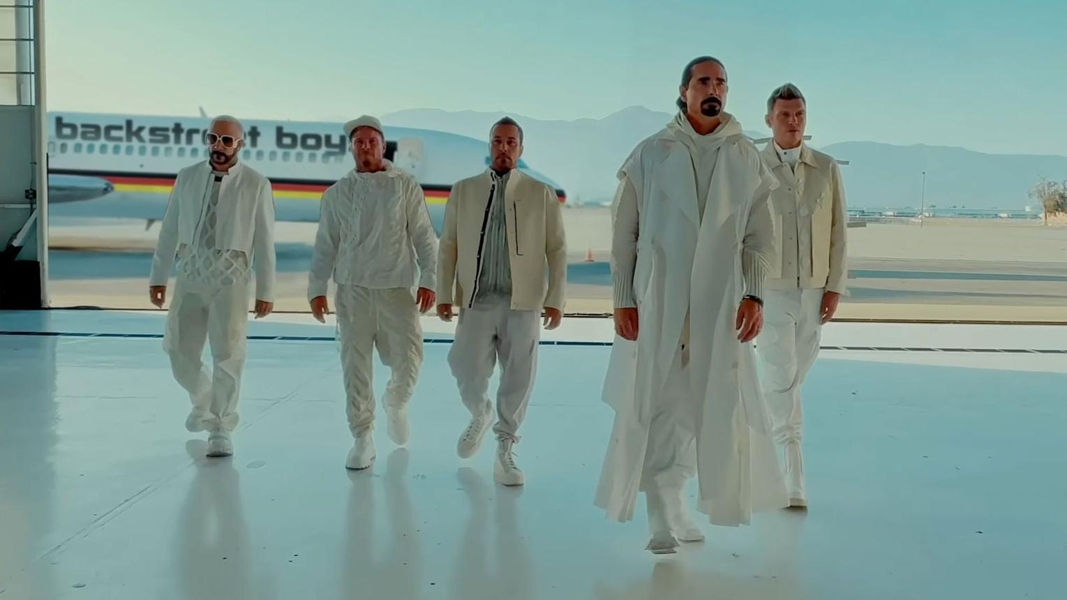 The Backstreet Boys in white outfits, recreating their airport music video
